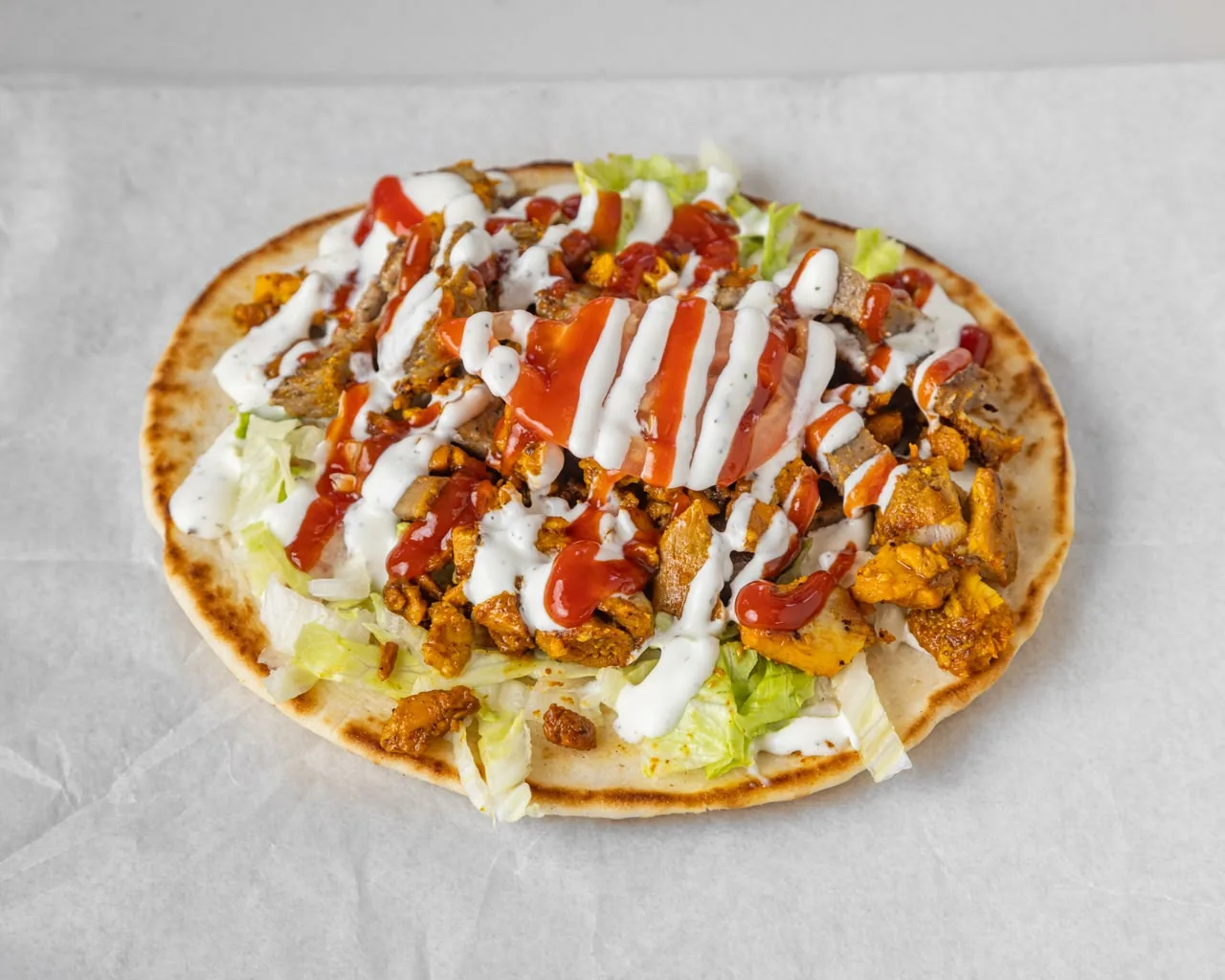 Gyro roll with meat, lettuce and sauces in a pita