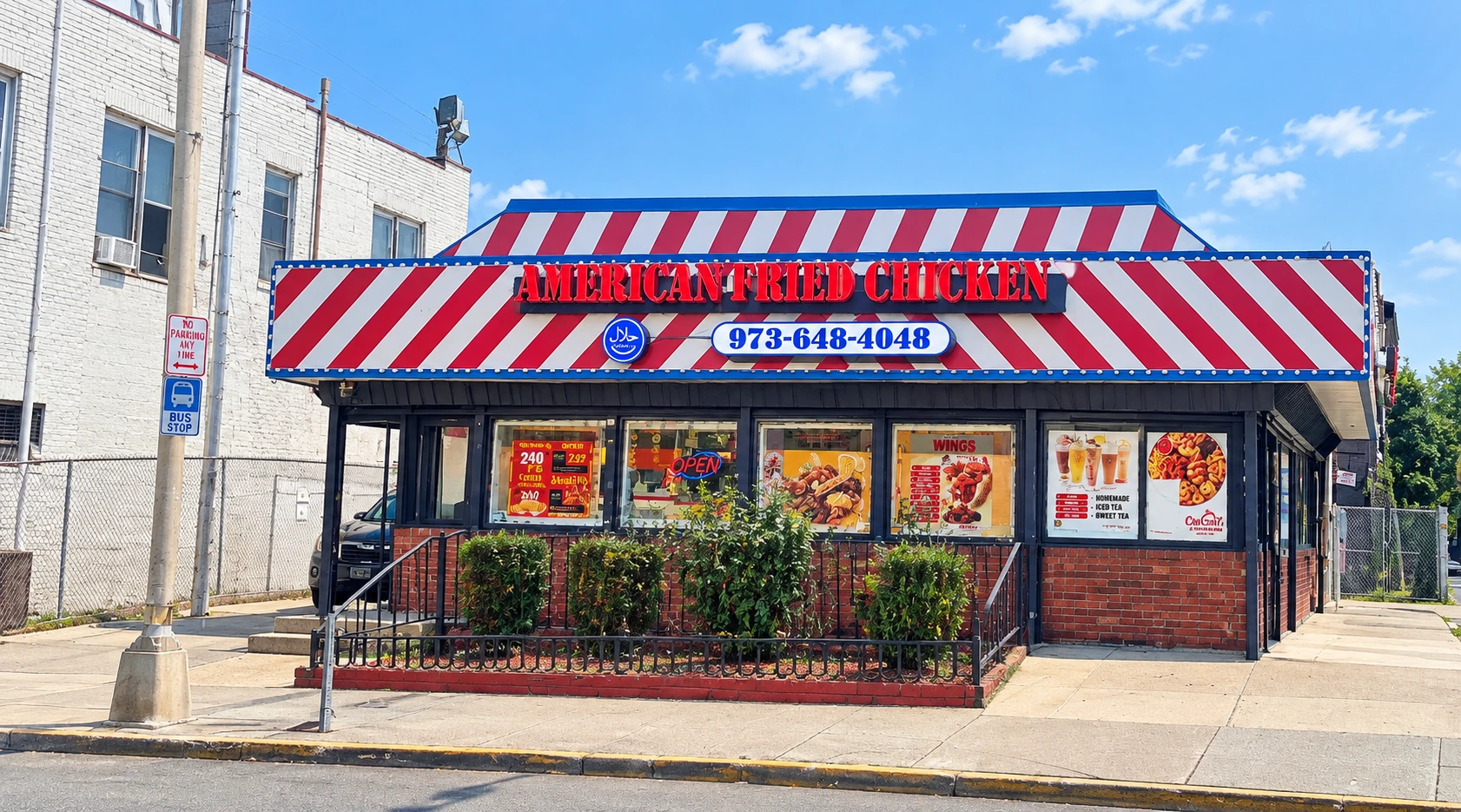 American Fried Chicken storefront with red and white striped awning during the day
